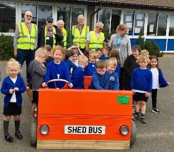 Schoolchildren with Looe Shedders volunteers and a wooden Shed Bus
