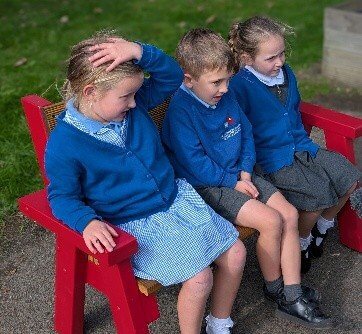 Children sitting on a red bench