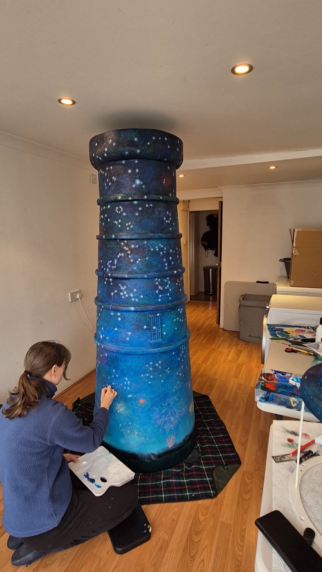 Diane Griffiths painting constellations onto the Celestial Beacon lighthouse sculpture