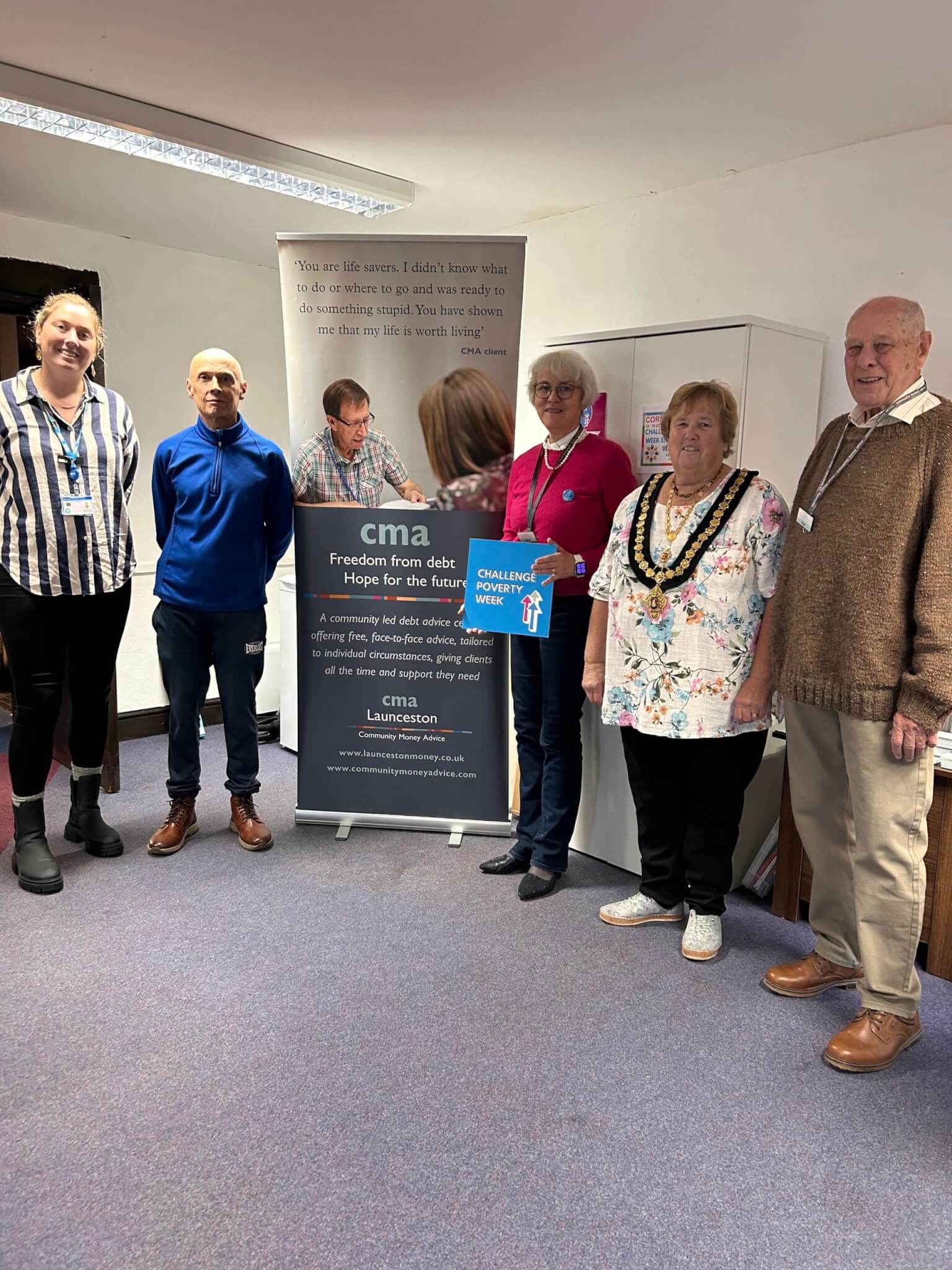 Guests and volunteers in front of the CMA Launceston banner