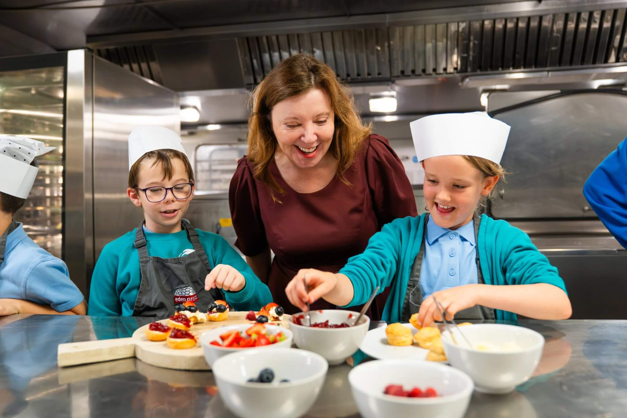 Dame Rachel de Souza with pupils preparing healthy food in the Biome Kitchen