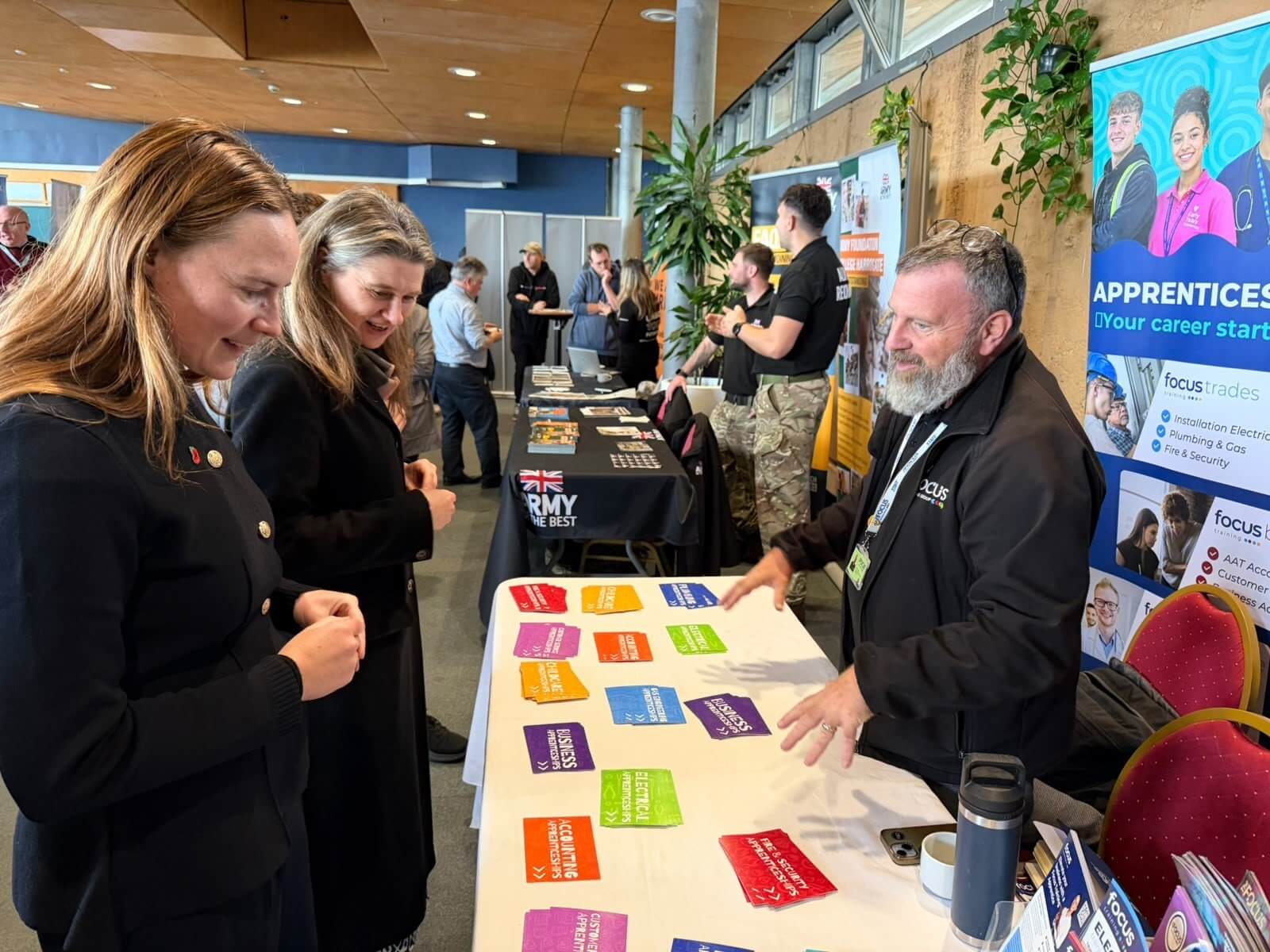 MPs Anna Gelderd and Jayne Kirkham looking at apprenticeship leaflets on a training stand at Cornwall's Jobs Fair, Eden Project