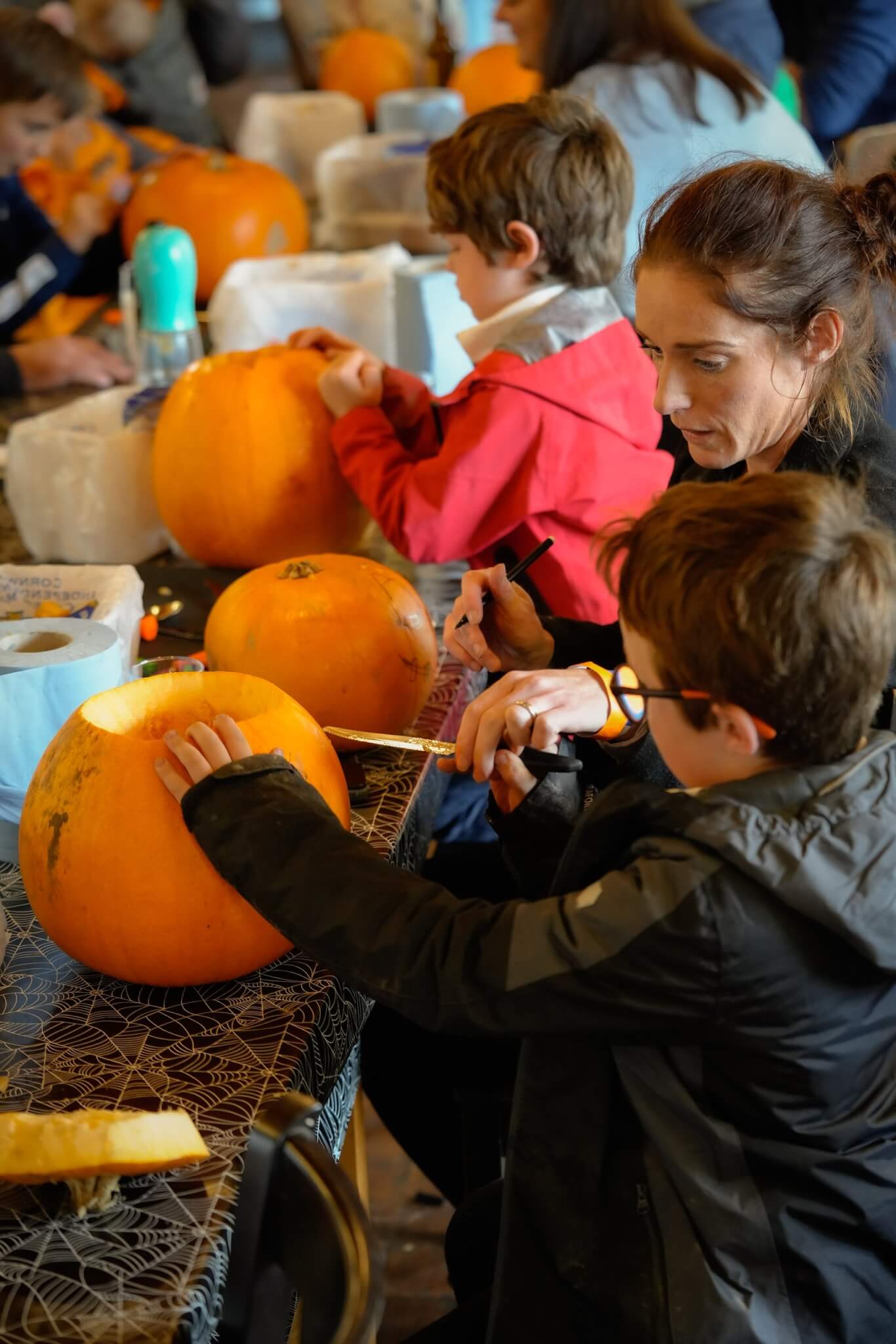 Children and an adult carving pumpkins
