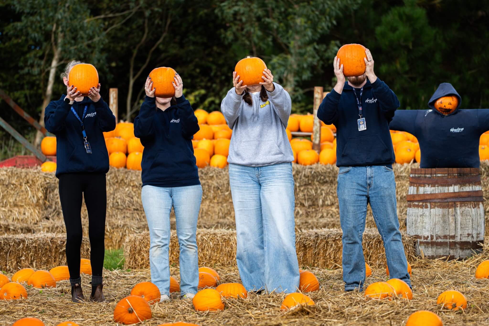 Healey's team holding pumpkins over their faces