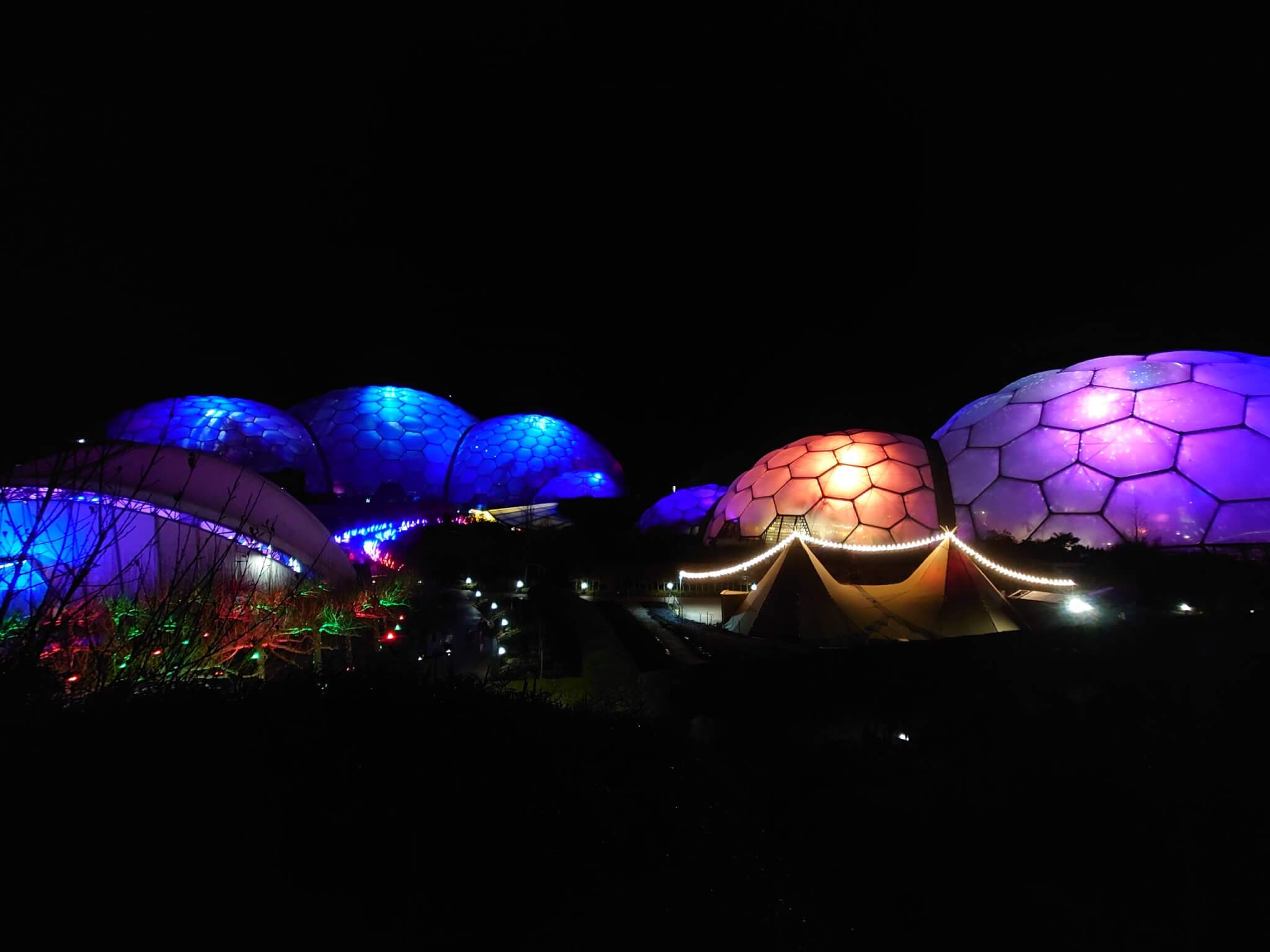 Eden Project biomes lit blue, purple and orange at night
