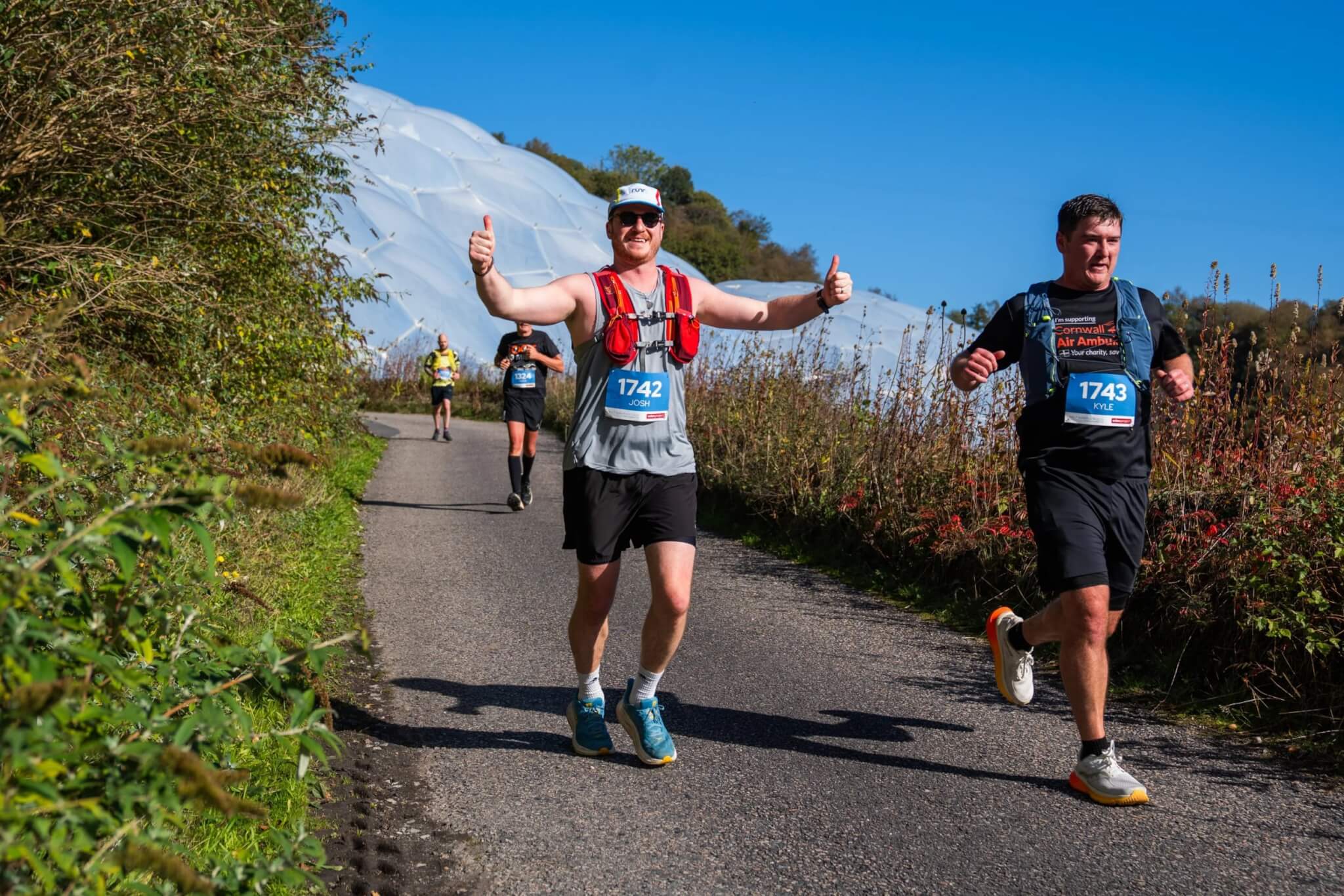 Smiling runners on a lane near the Eden Project
