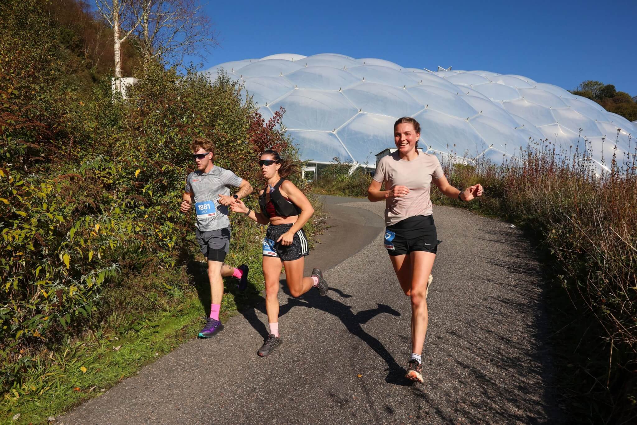 Runners passing the Eden Project Biomes