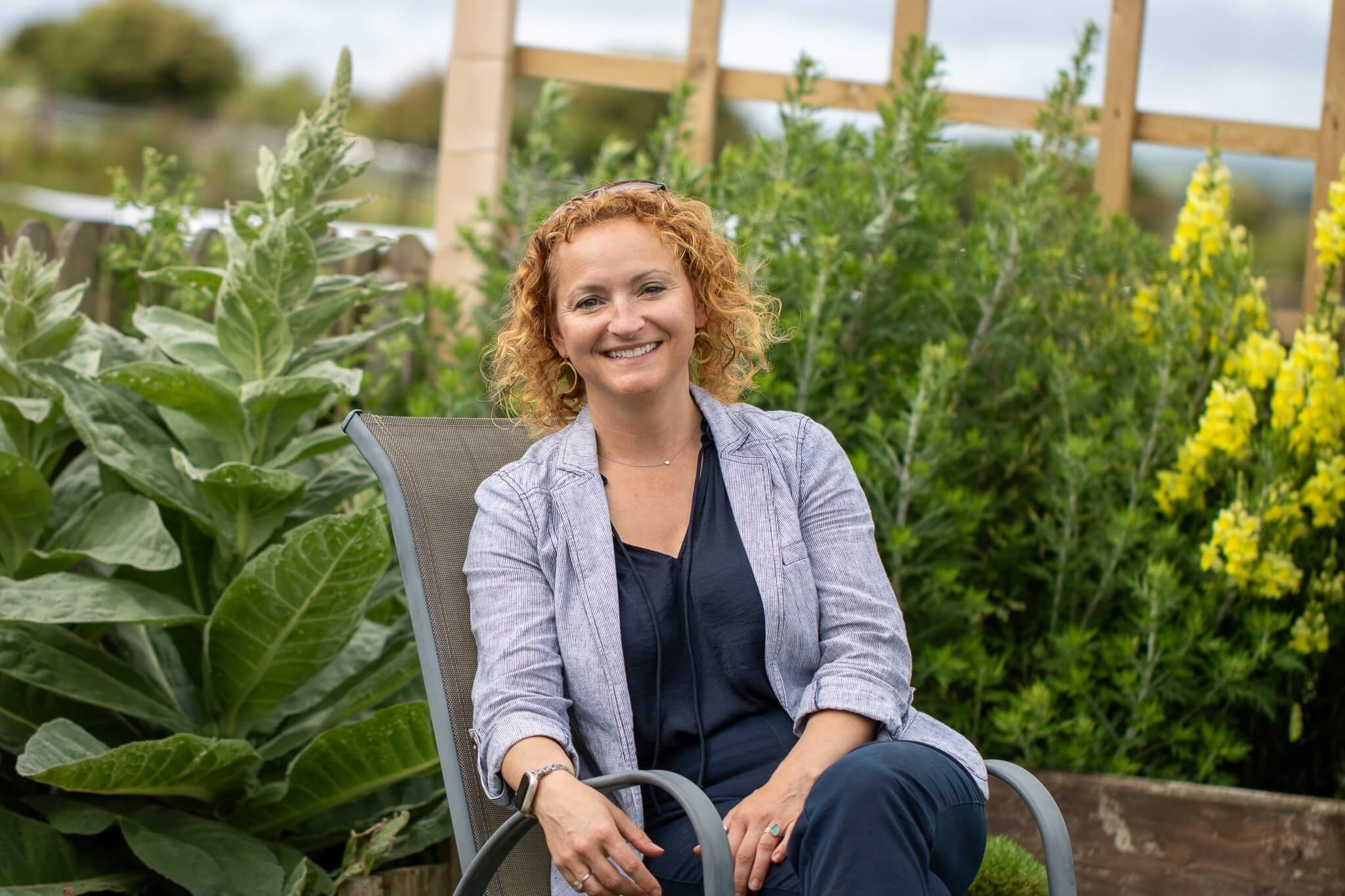Emma Rowse sitting in a garden chair, smiling