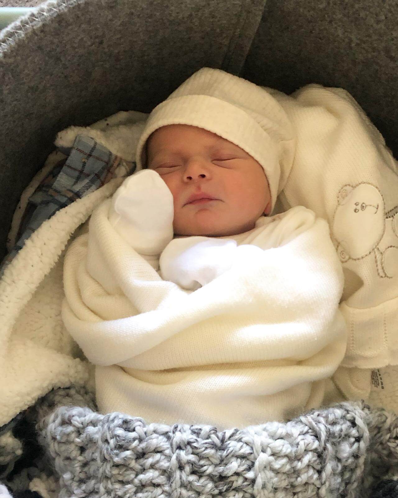 Baby Ezrah asleep in his Moses basket