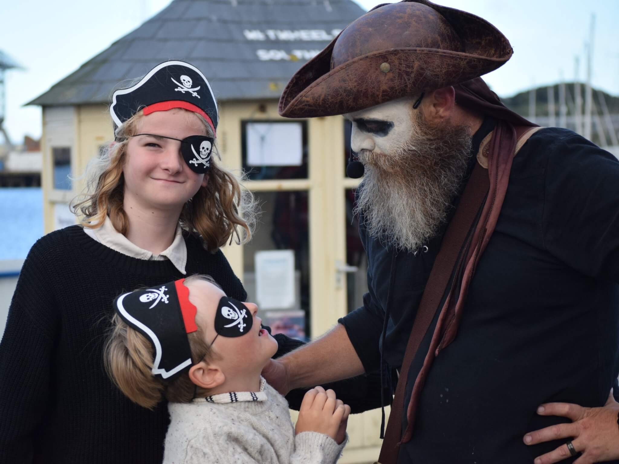 Children in pirate hats and eye patches with a costumed pirate guide in Falmouth