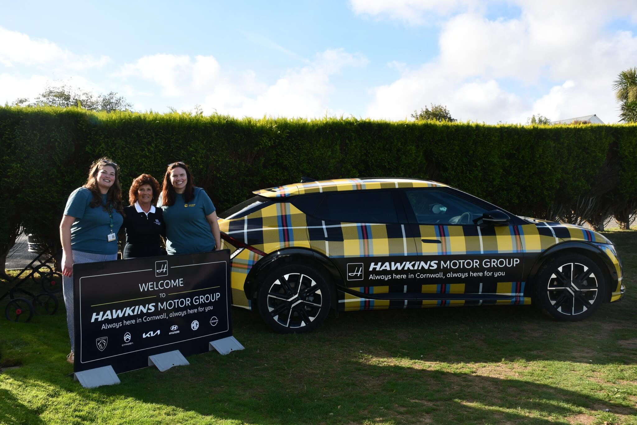 Hawkins Motor Group team beside the Cornish tartan Kia EV6 at Carlyon Bay Golf Club