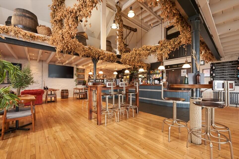 Inside the Hicks Bar at St Austell Brewery, with dried hops hanging from the beams