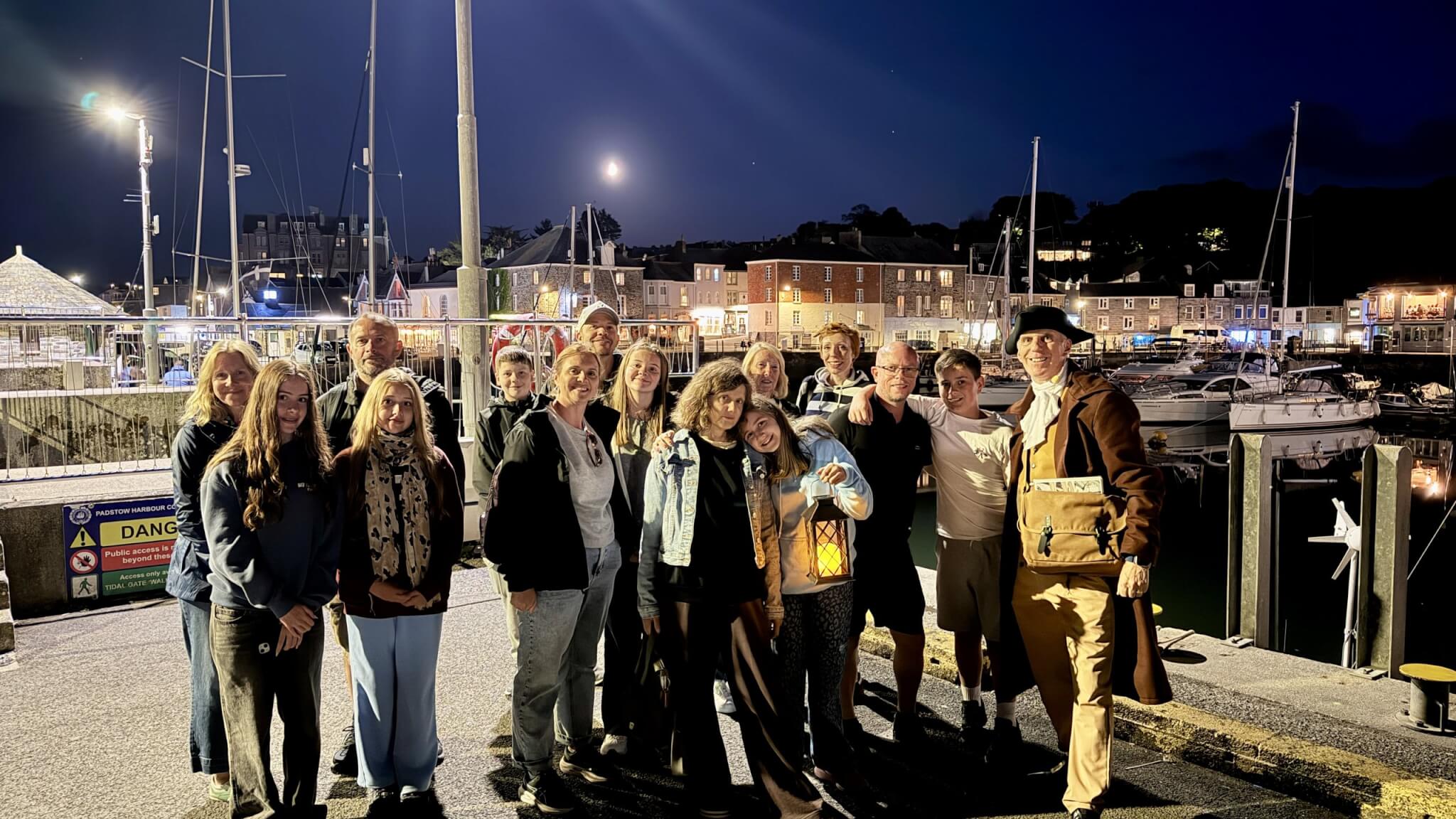 A Ghost Walk group with the costumed guide on Padstow Harbour at night