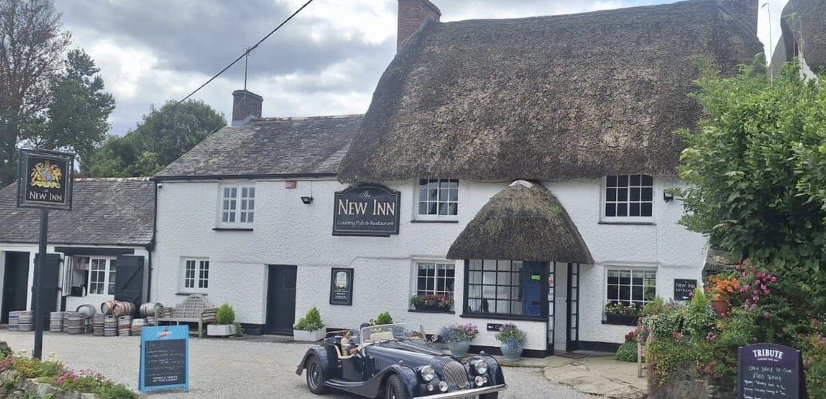 The thatched New Inn pub in Manaccan, with a classic car parked outside