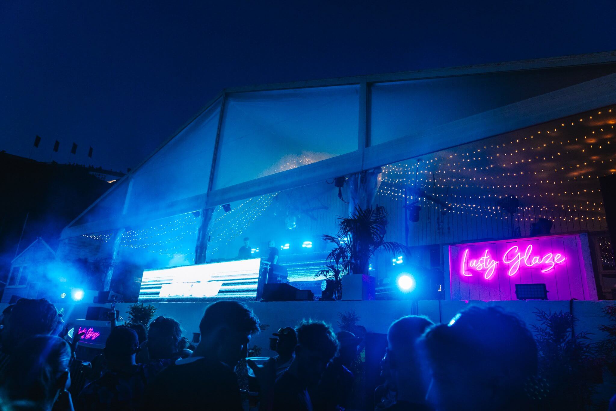 Lusty Glaze neon sign lit up blue at night
