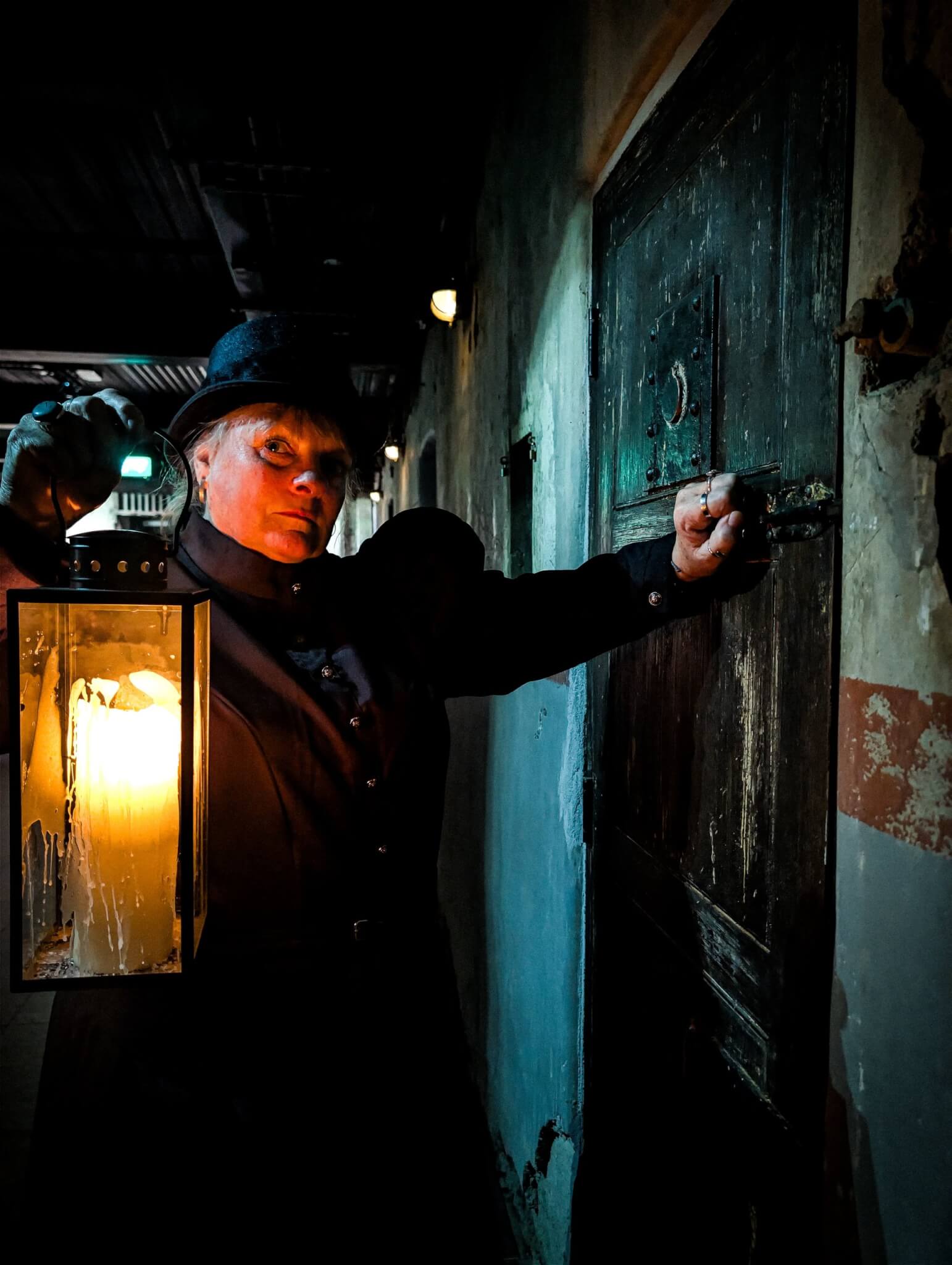 Ghost Walk guide with a lantern opening a cell door at Bodmin Jail