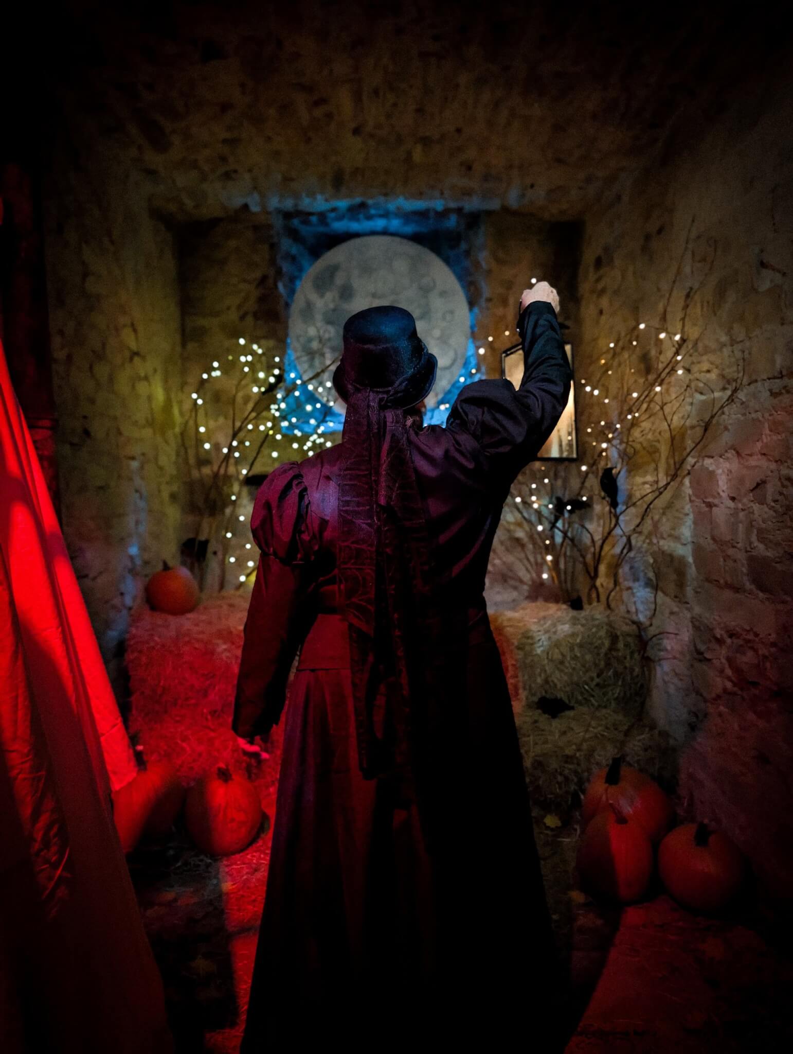 Costumed guide raising a lantern beneath a full moon display at Bodmin Jail