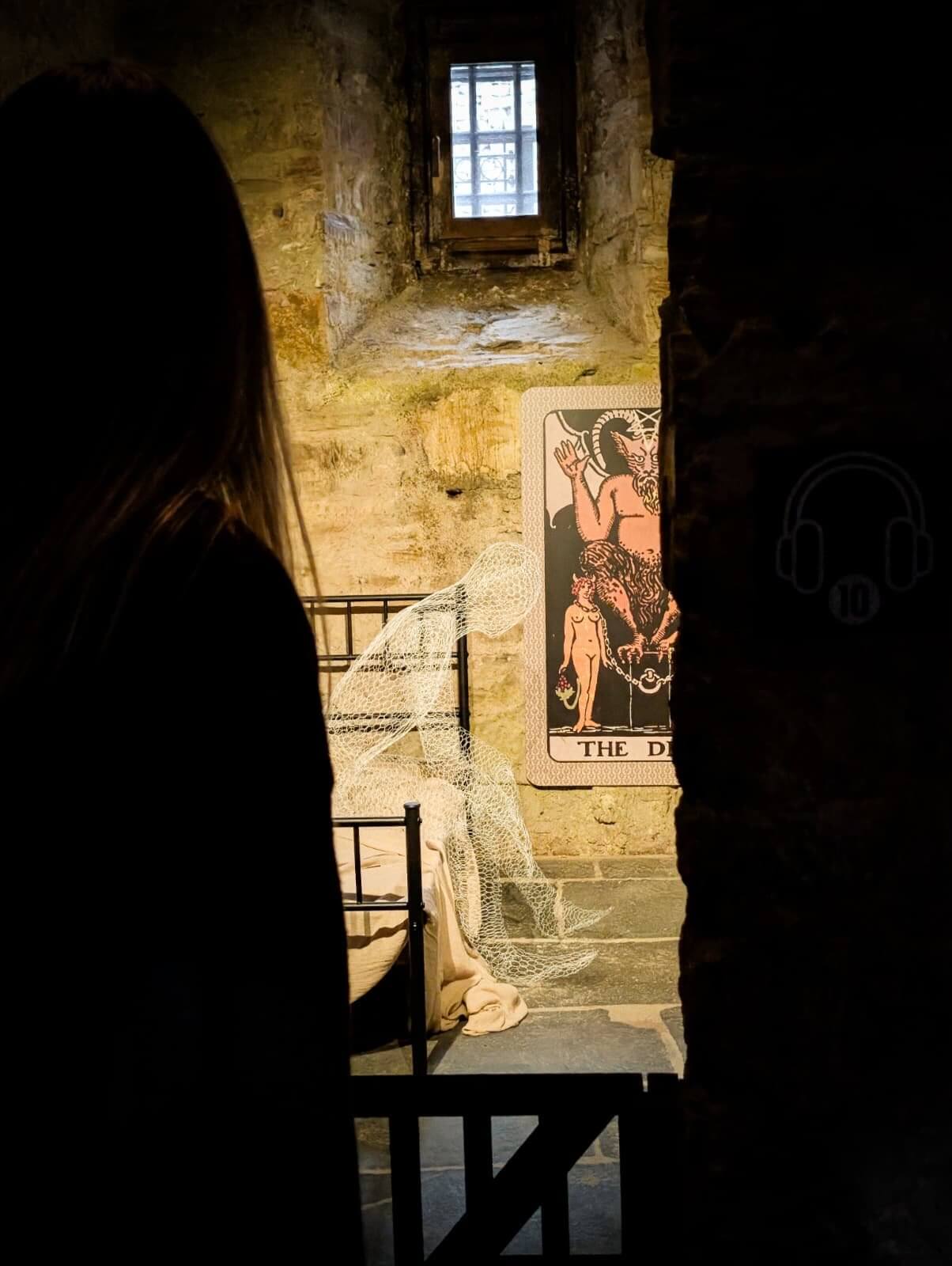 Silhouetted visitor in a dark cell corridor at Bodmin Jail