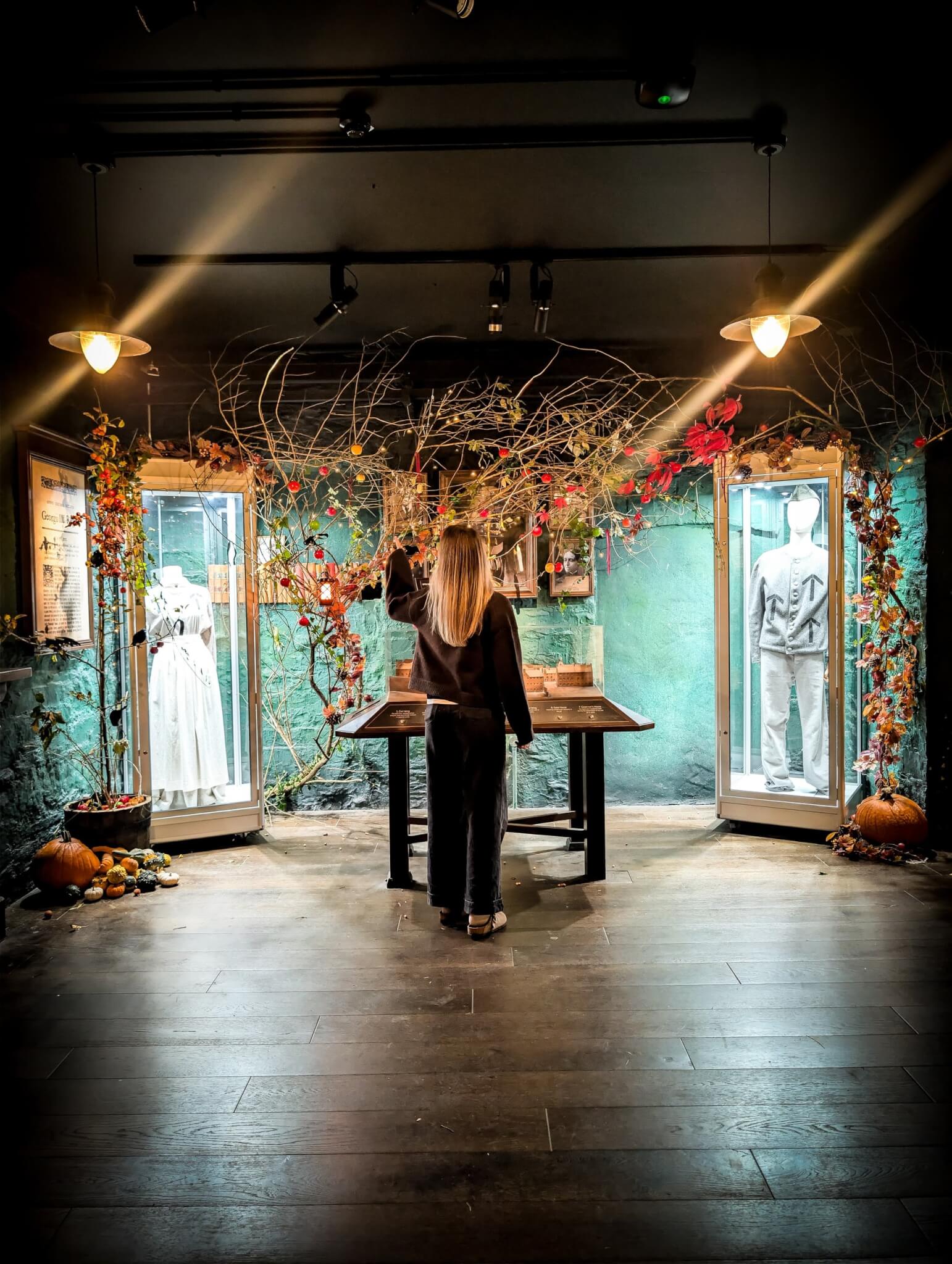 Visitor exploring a Halloween-decorated gallery at Bodmin Jail