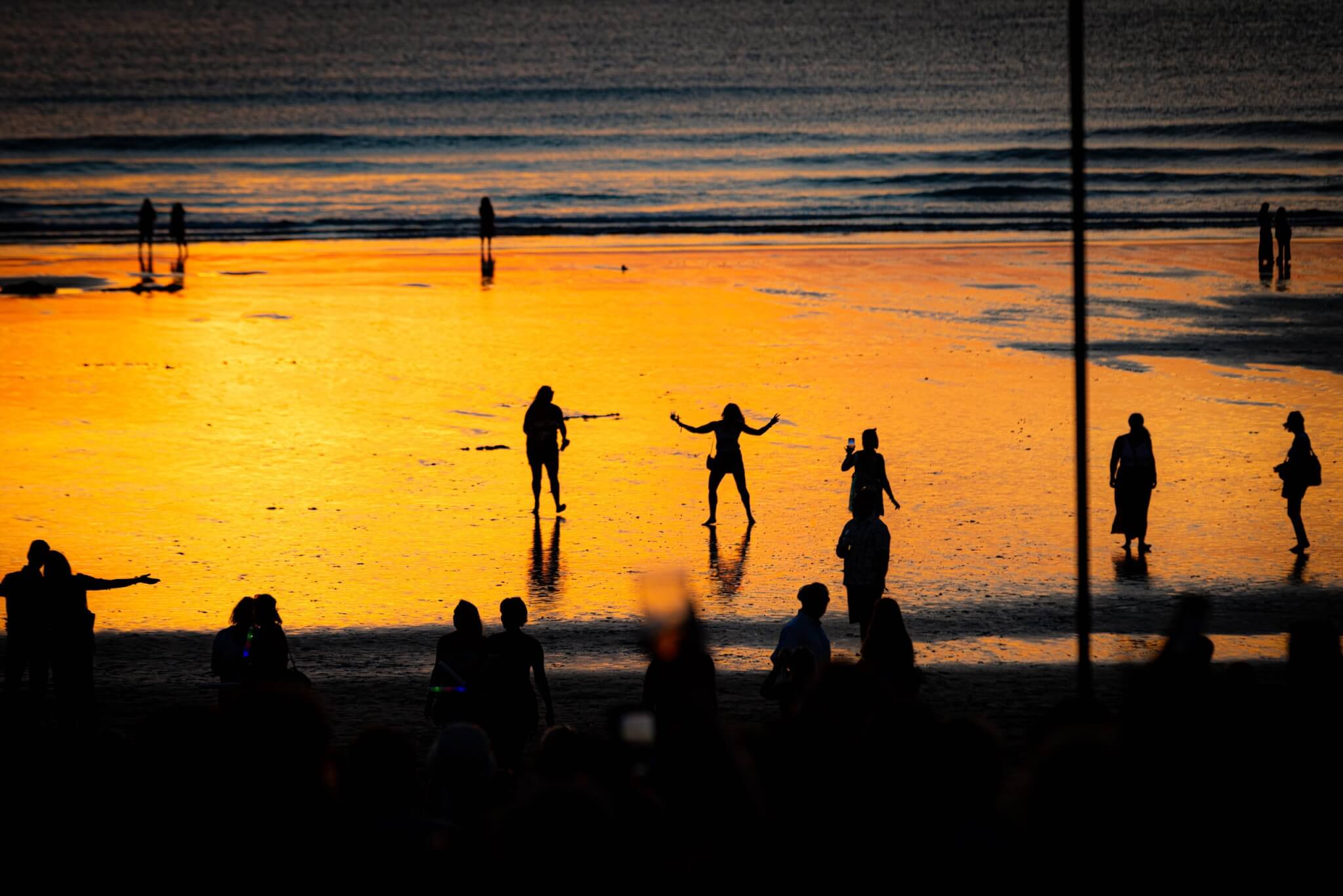 Dancers silhouetted on the sand at sunset