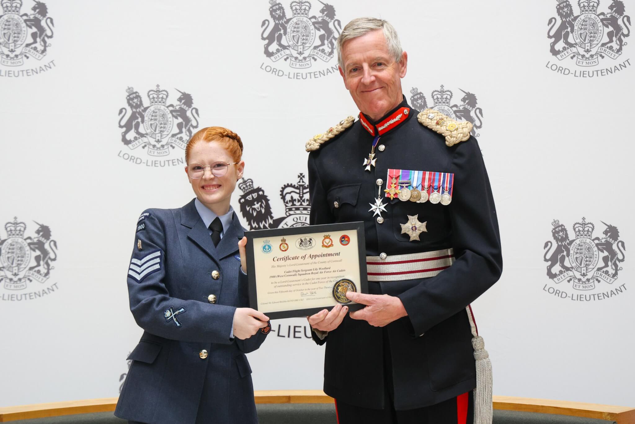Cadet Flight Sergeant Lily Woollard receiving her certificate from Colonel Sir Edward Bolitho