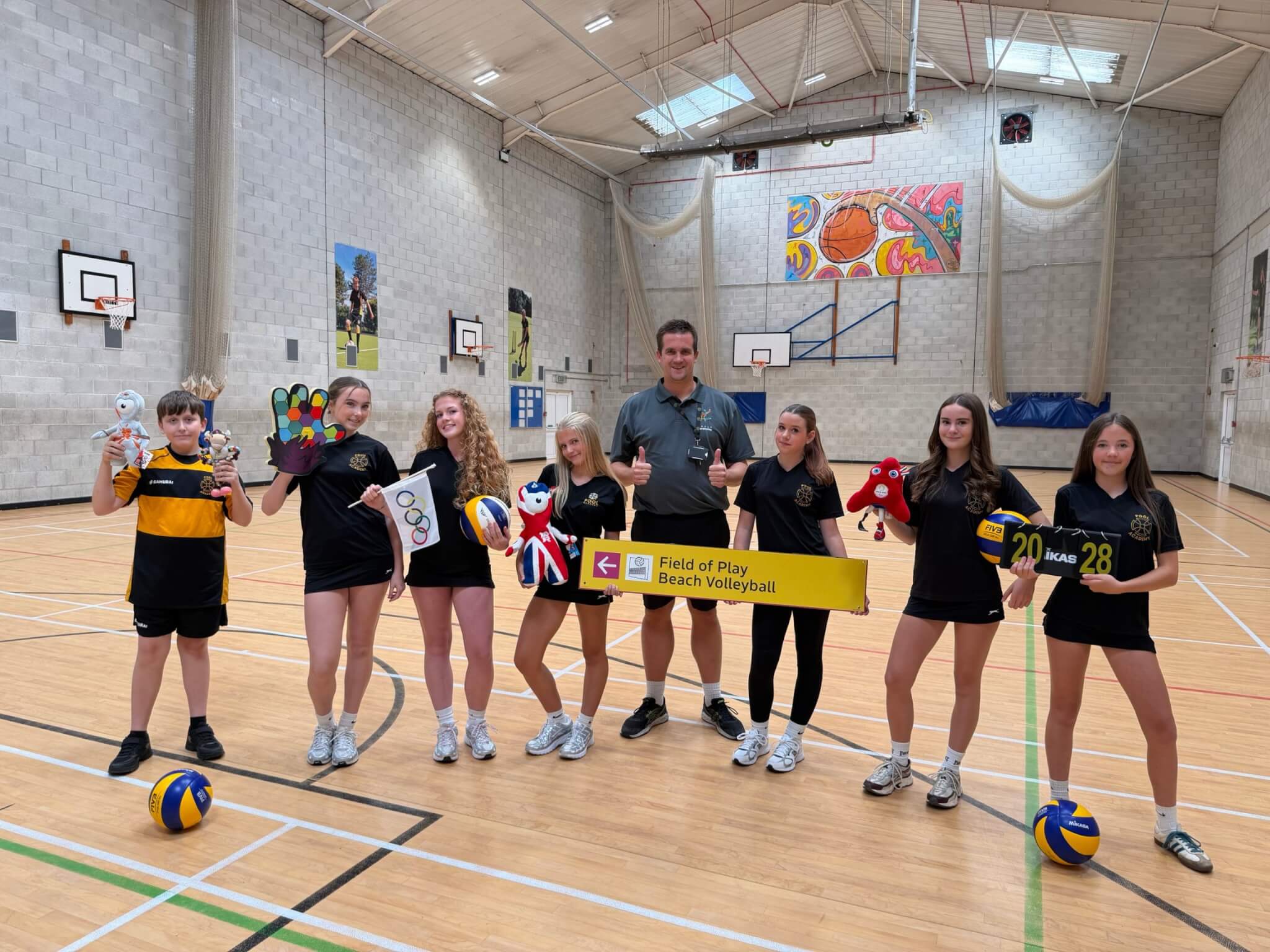 Matt Rogers with Pool Academy students holding Olympic and Paralympic memorabilia