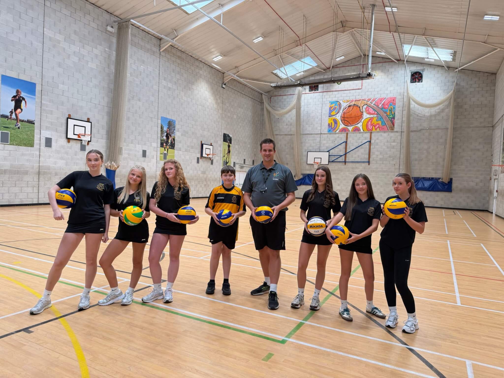 Matt Rogers and Pool Academy students holding volleyballs