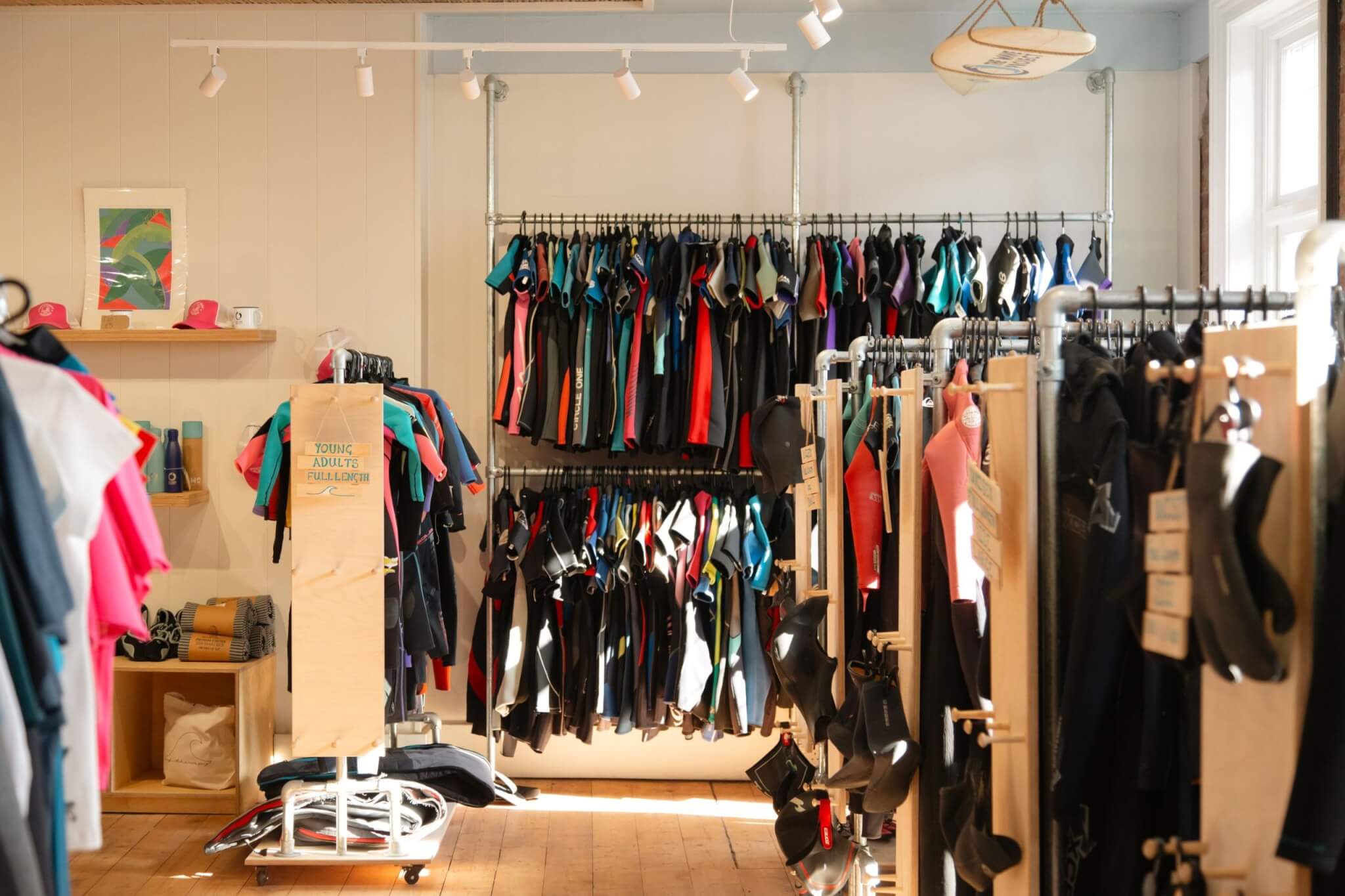 Racks of second-hand wetsuits in The Wave Project shop, Newquay