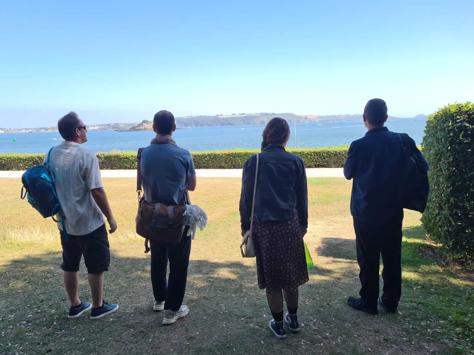 Four people standing on grass looking out over the water from Torpoint