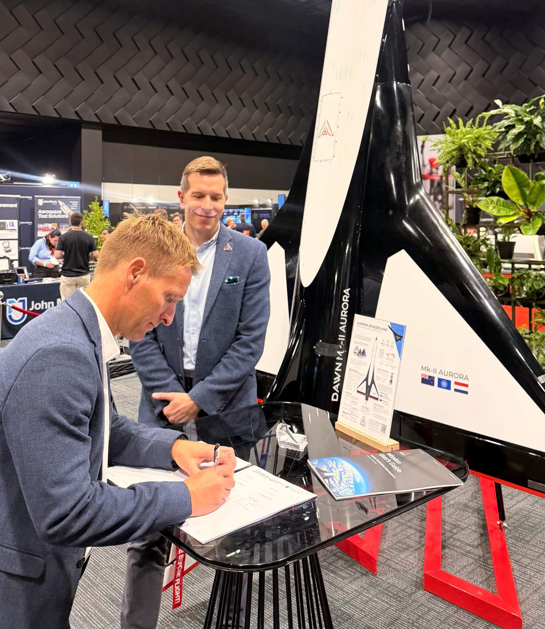 The Dawn Aerospace and Spaceport Cornwall MoU being signed beside a model of the Aurora spaceplane