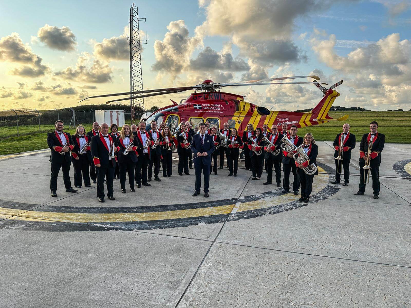 St Dennis Band in front of the Cornwall Air Ambulance helicopter