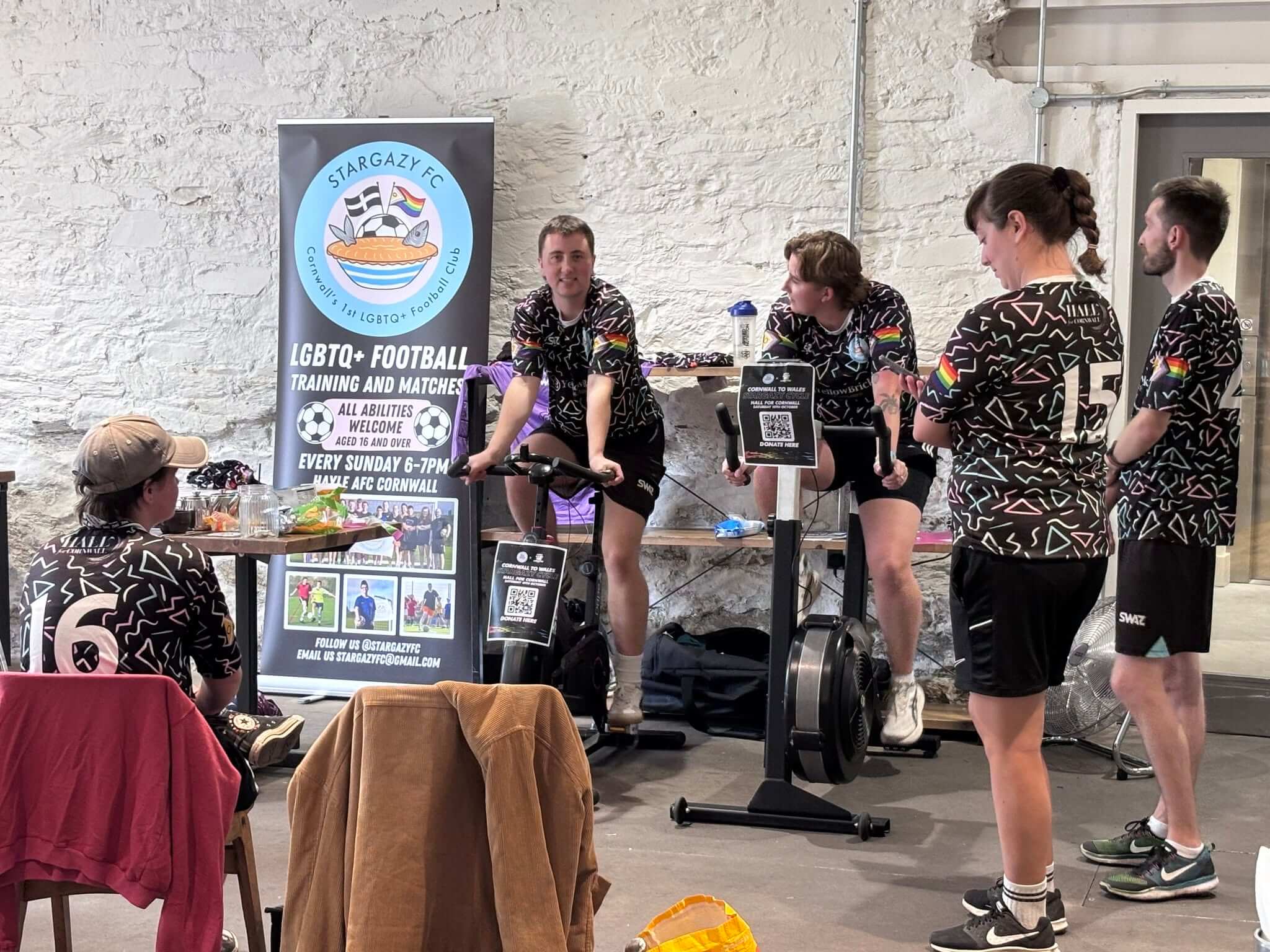 Stargazy FC players on exercise bikes beside the club banner