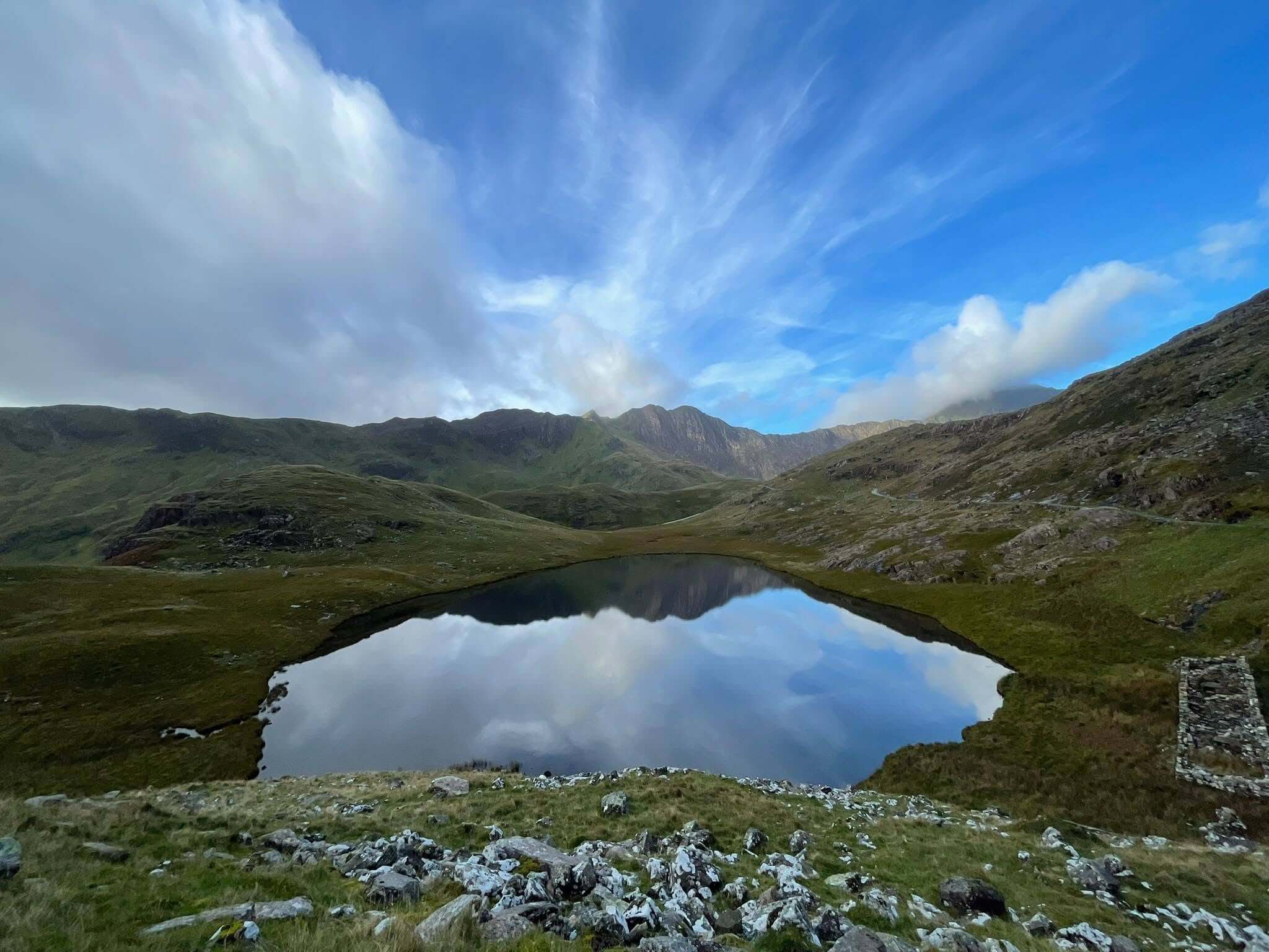 Mountain lake reflecting blue sky below Snowdon