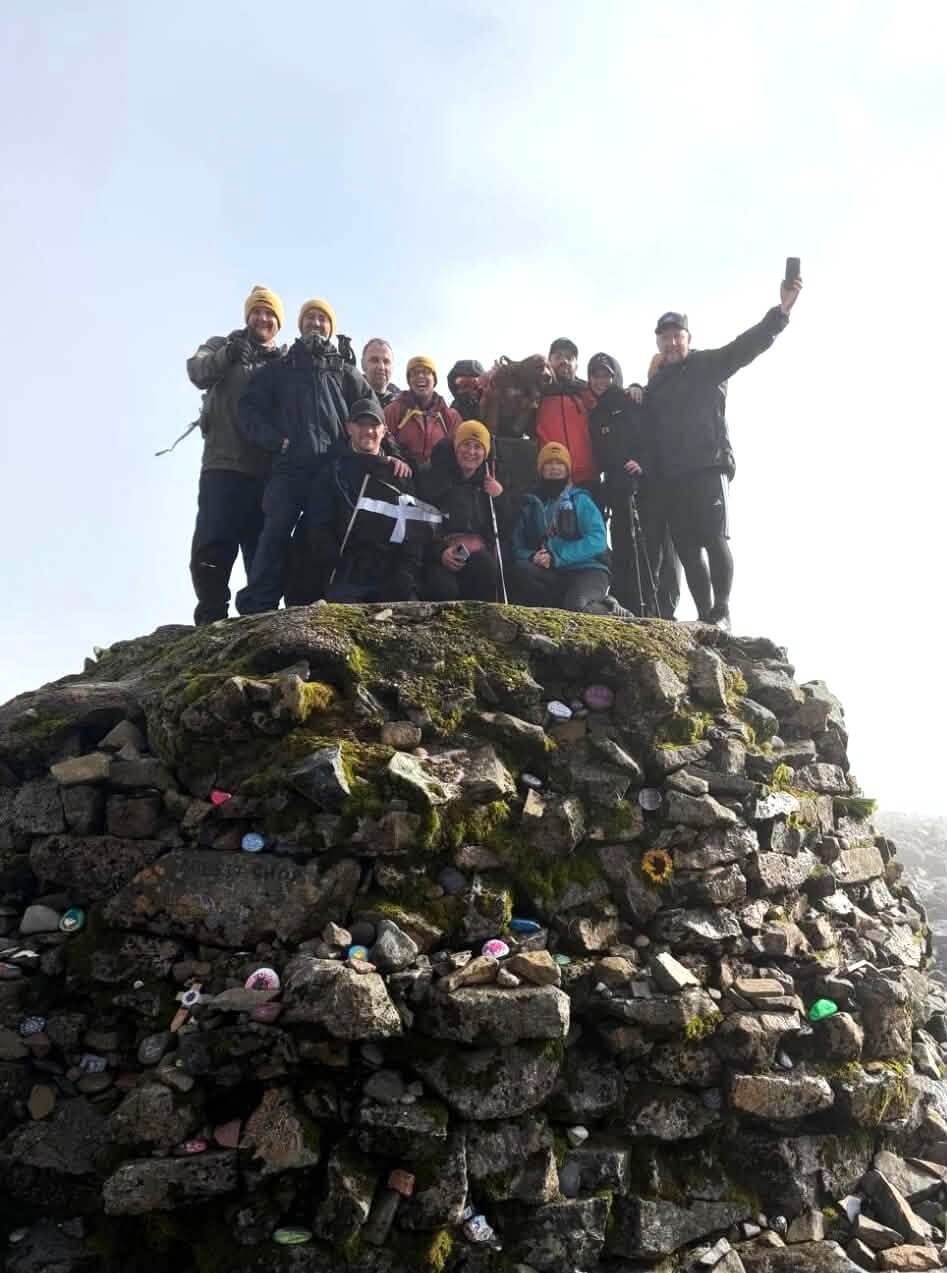 Sunrise Cornwall CIC team with a Cornish flag on the summit of Ben Nevis