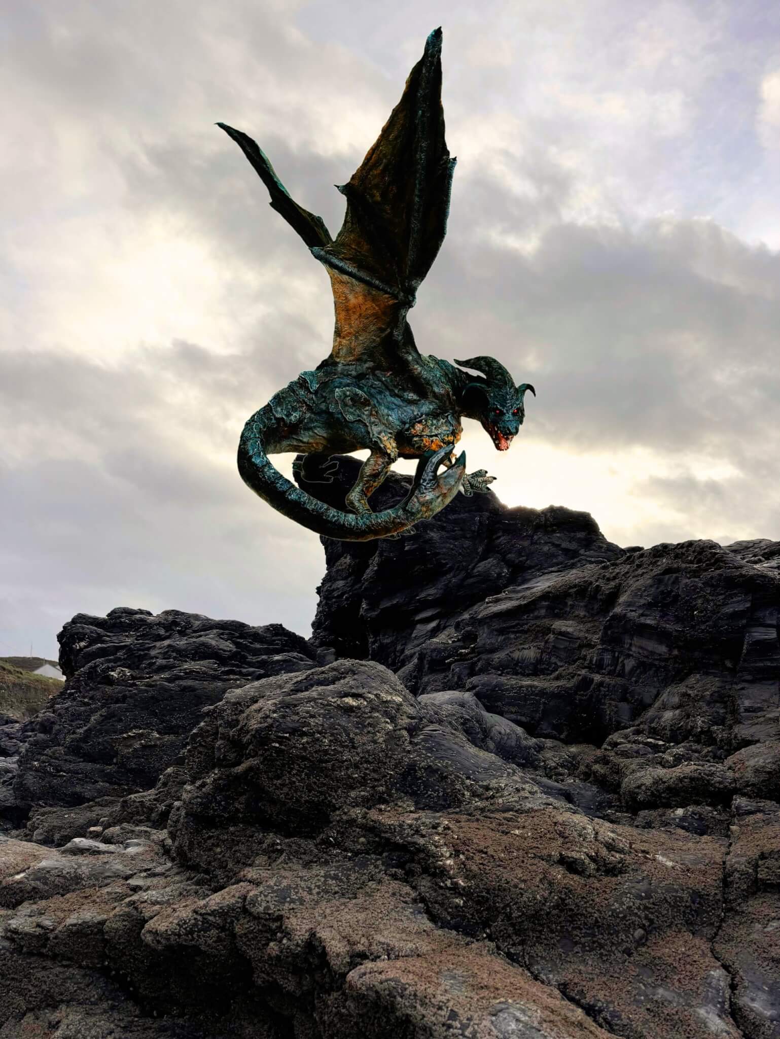 Dragon of Porthtowan sculpture perched on rocks