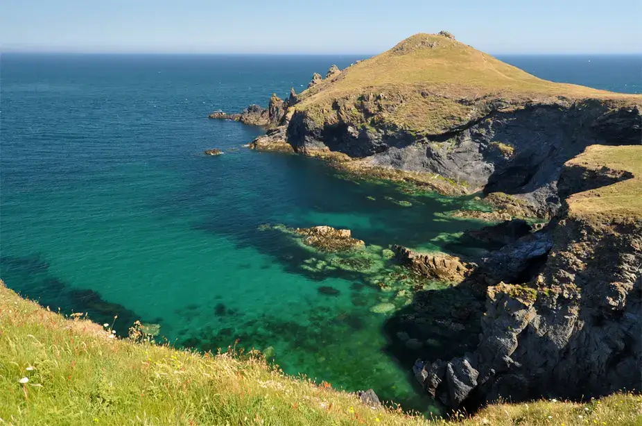 The Rumps headland above clear turquoise water near Polzeath
