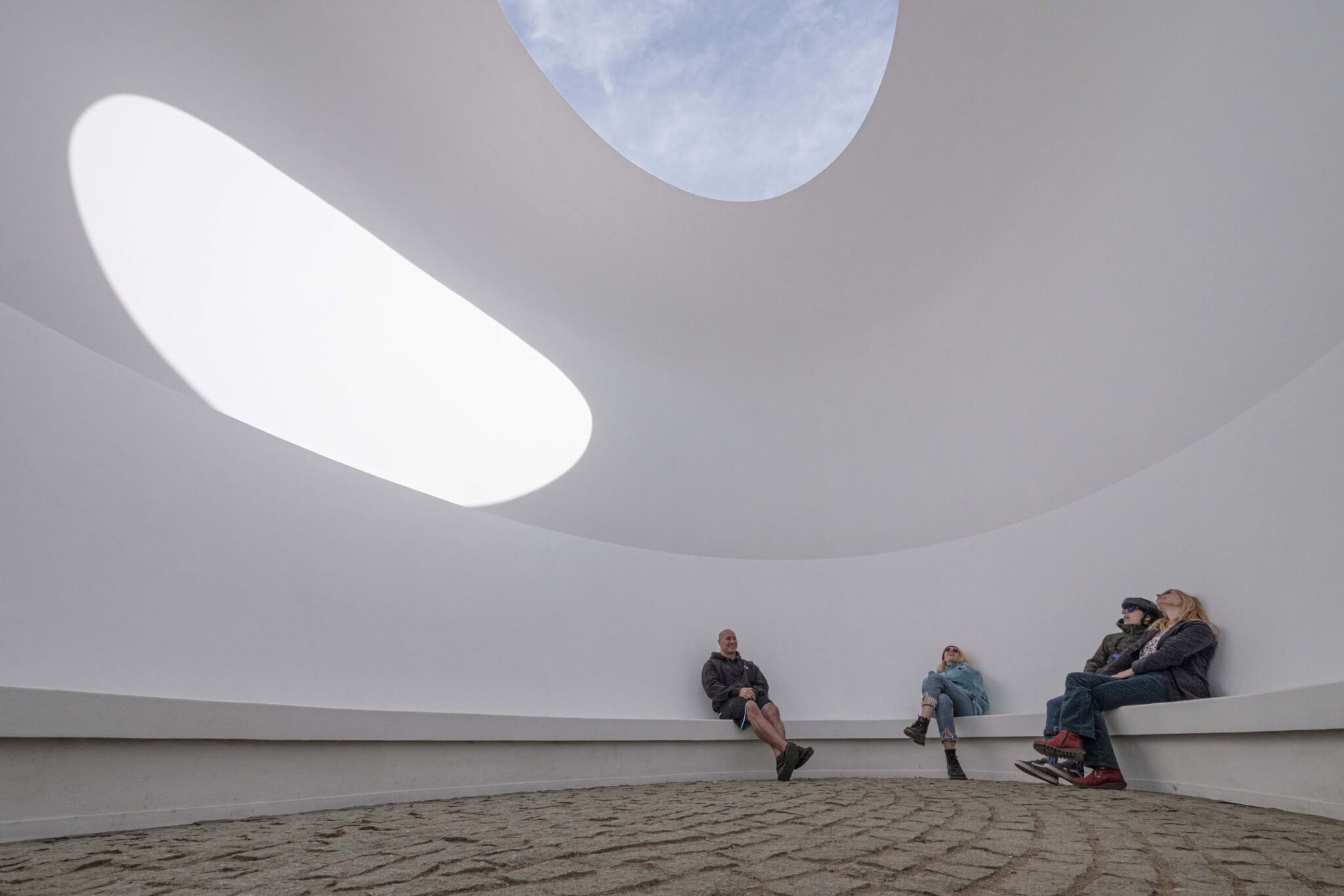 Visitors looking up at the sky inside the James Turrell Skyspace at Tremenheere