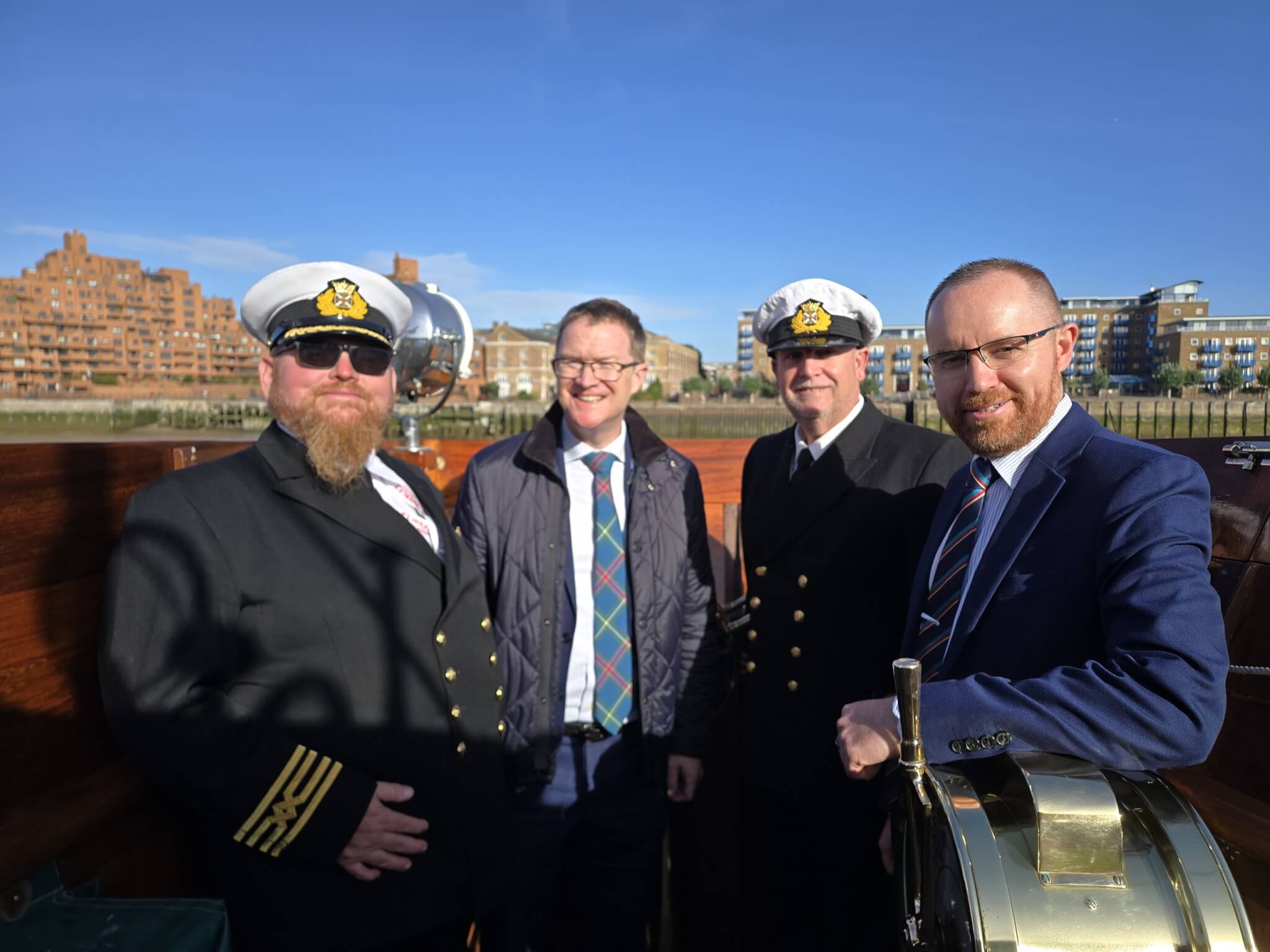 Four men, two in ship's officer uniform, on the deck of Waverley