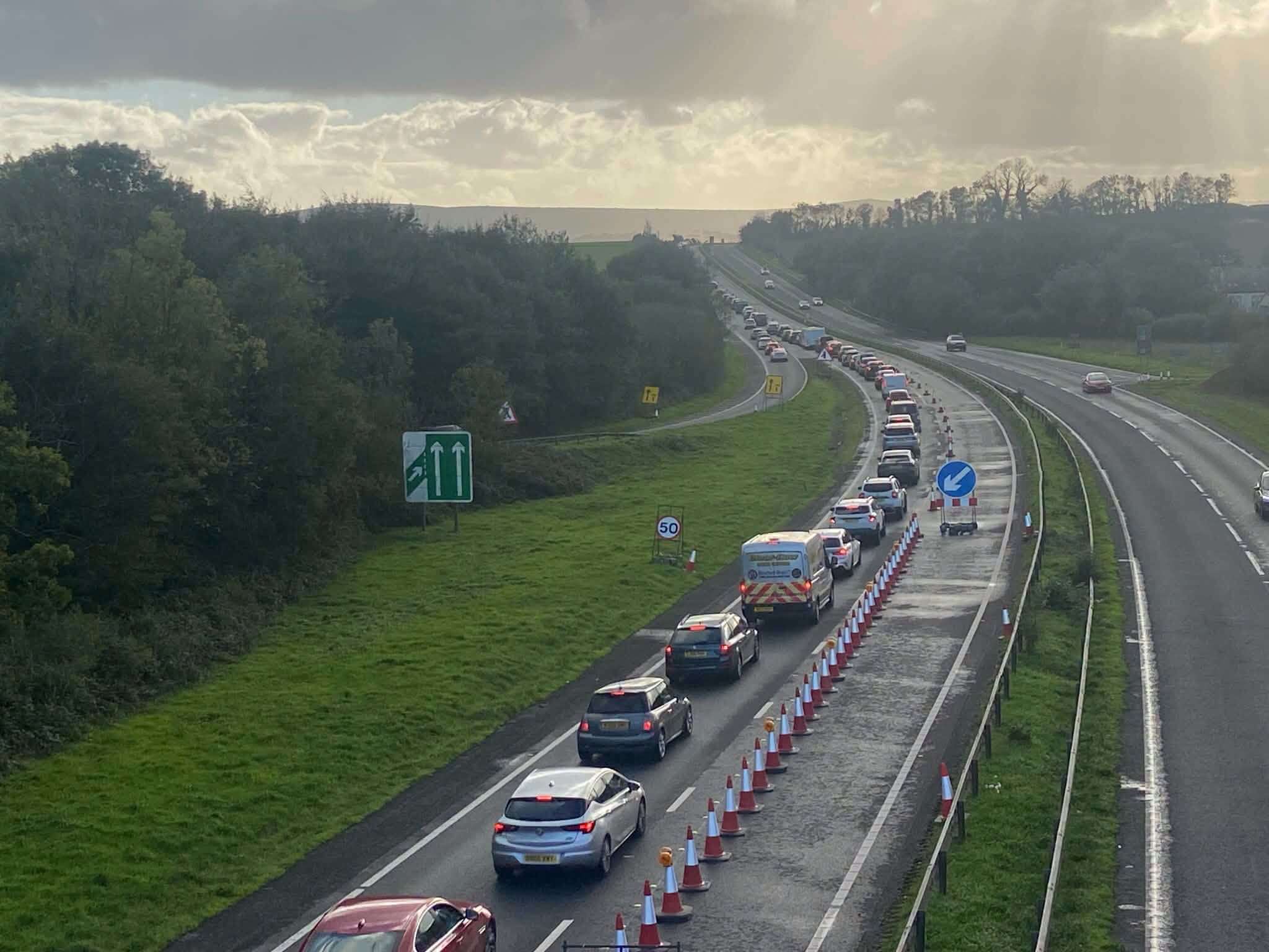 Queue of traffic in a single coned-off lane on the A30 during safety roadworks