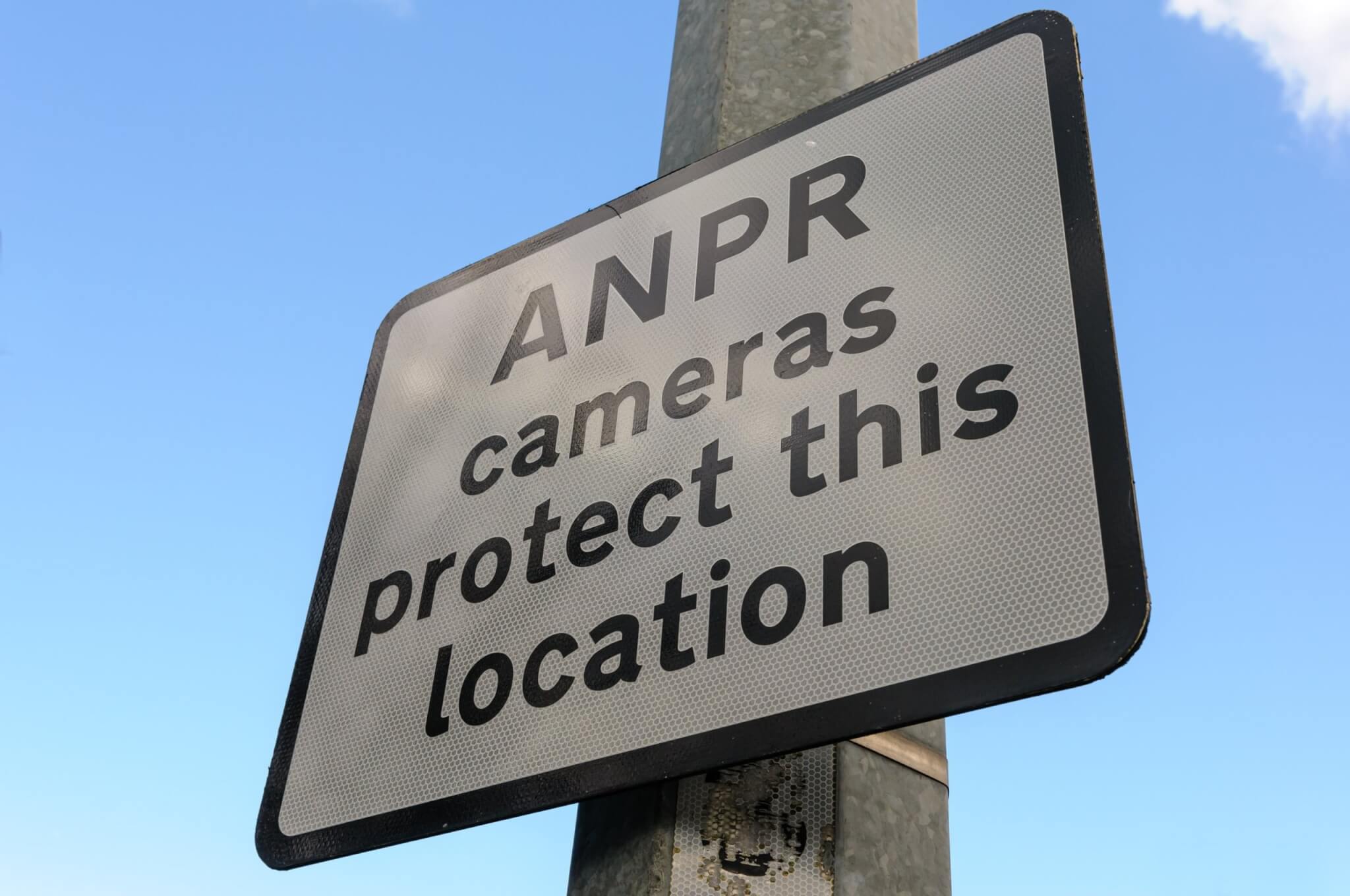 Sign reading ANPR cameras protect this location on a lamp post