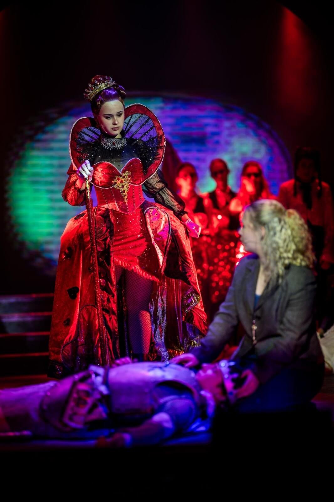 The Queen of Hearts in a red gown in BOOM Theatre's Wonderland the Musical