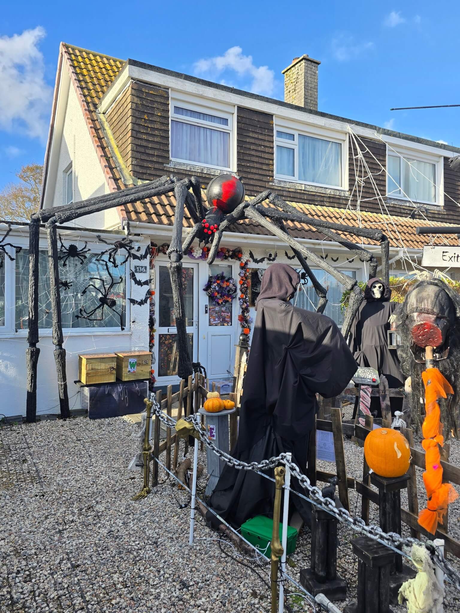 Giant homemade spider FANG straddling the front of a house on Boslowick Road, Falmouth