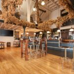 Inside the Hicks Bar at St Austell Brewery, with dried hops hanging from the beams