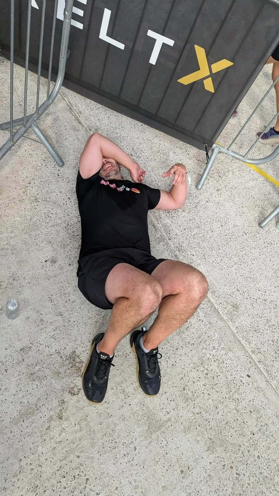 Exhausted competitor lying flat on his back beside KeltX barriers