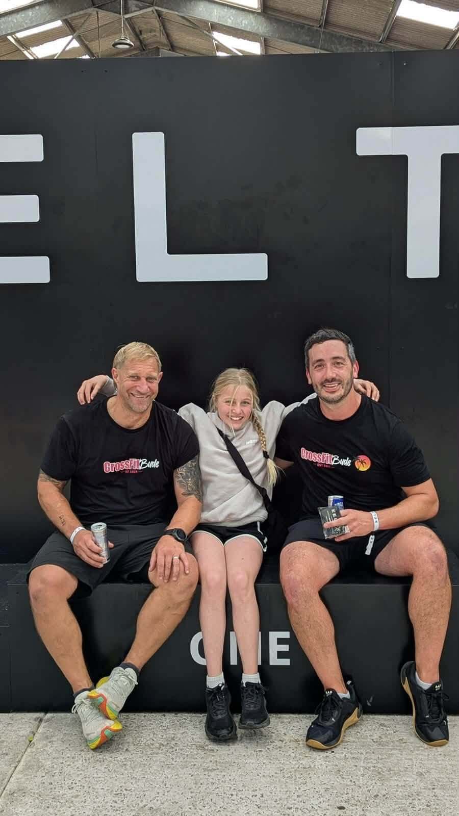 Two Bude lifeboat crew members and a young competitor sitting in front of the KeltX sign