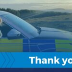 Police dog leaning out of a Devon and Cornwall Police car window with a thank you banner