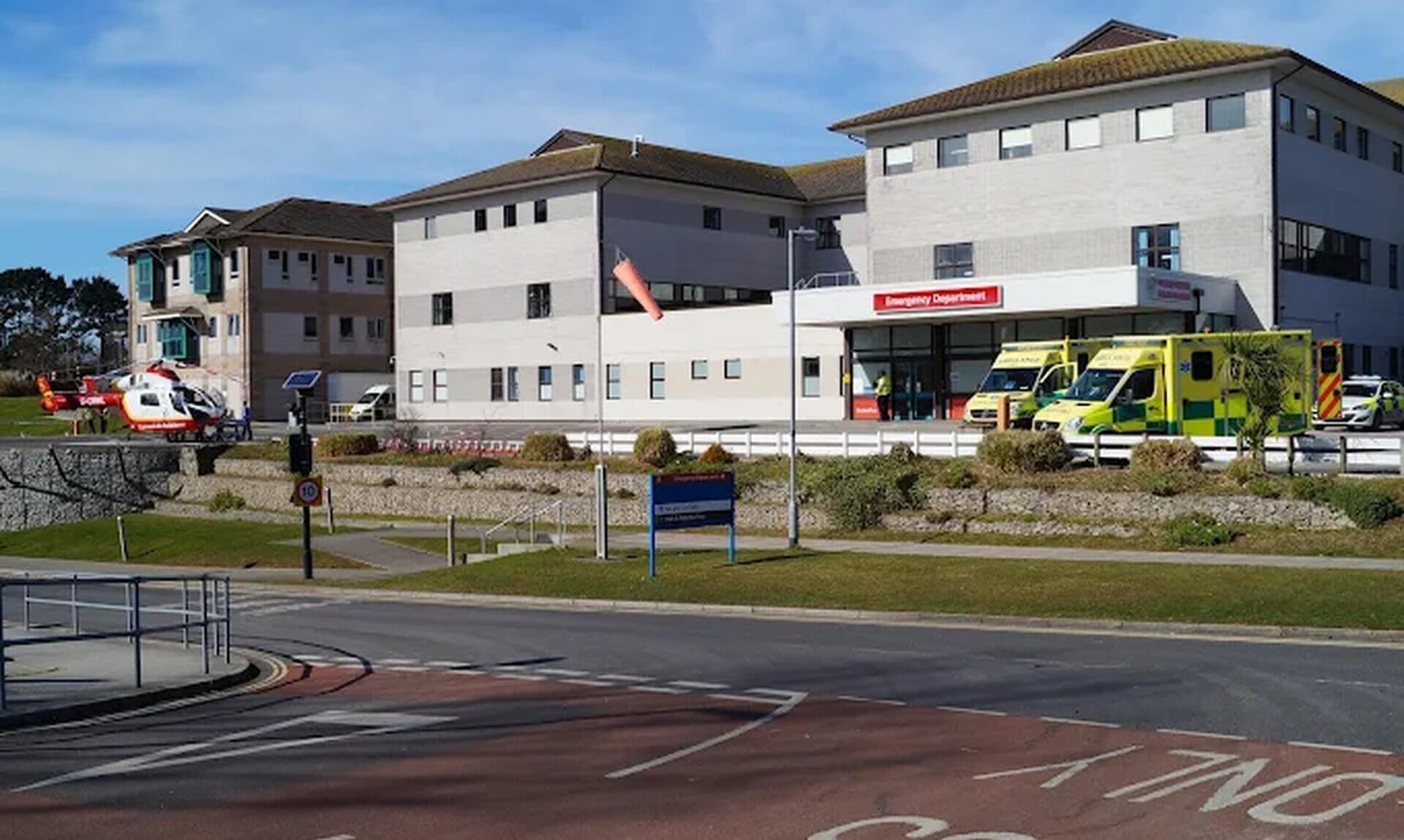 Hospital emergency department entrance with ambulances parked outside and an air ambulance helicopter
