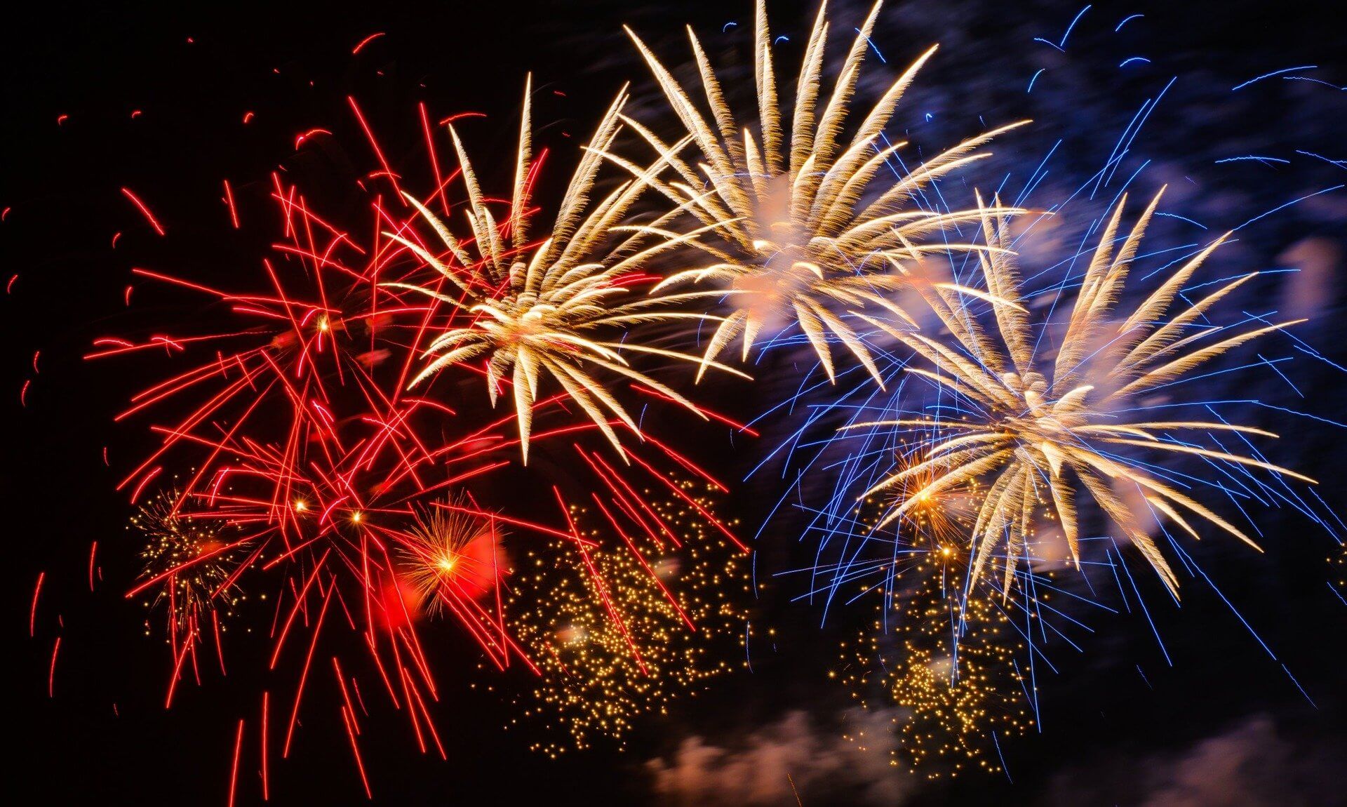 Red, gold and blue fireworks bursting in the night sky