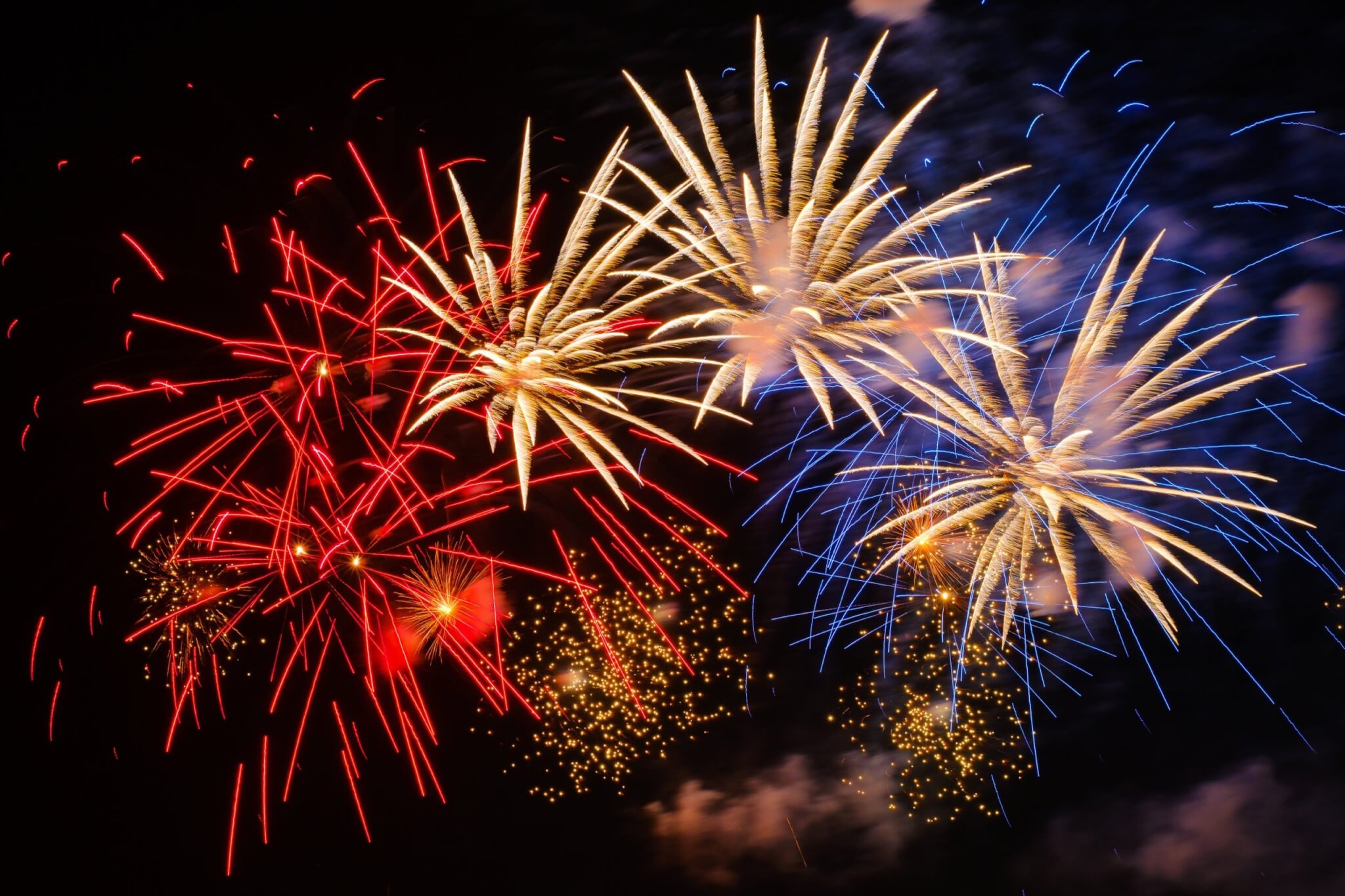 Red, gold and blue fireworks bursting in the night sky