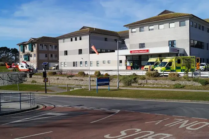 Hospital emergency department entrance with ambulances parked outside and an air ambulance helicopter